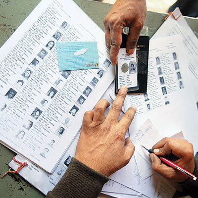 a person's hands holding pen to correct voter id