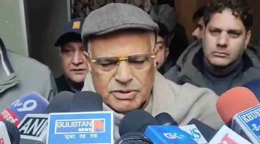 Person speaking to media microphones.